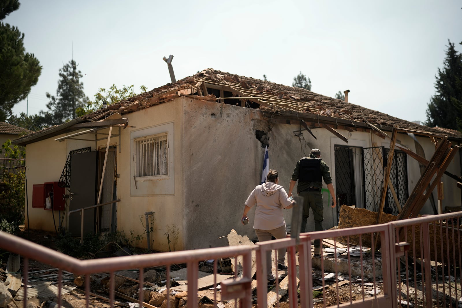 People look at a damaged house that was hit by a rocket fired from Lebanon, near Safed, northern Israel, on Wednesday, Sept. 25, 2024. (AP Photo//Leo Correa)