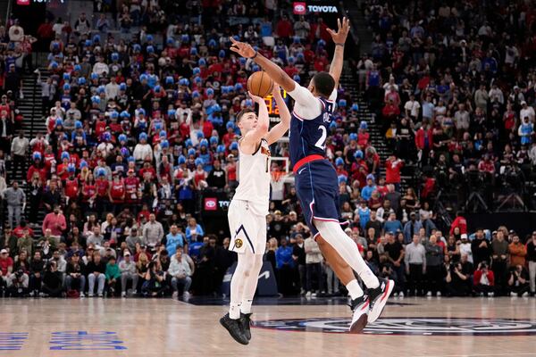 Denver Nuggets guard Christian Braun, left, shoots as Los Angeles Clippers guard Norman Powell defends during the second half in Game 4 of an NBA basketball first-round playoff series Saturday, April 26, 2025, in Inglewood, Calif. (AP Photo/Mark J. Terrill)