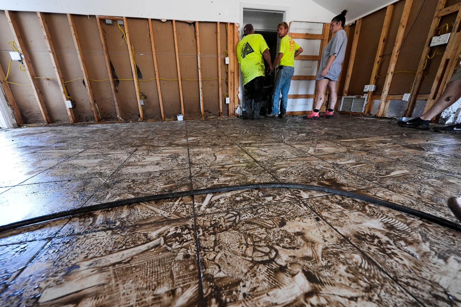 Workers clean and gut a property that was flooded from the storm surge, in the aftermath of Hurricane Helene, in Steinhatchee, Fla., Sunday, Sept. 29, 2024. (AP Photo/Gerald Herbert)