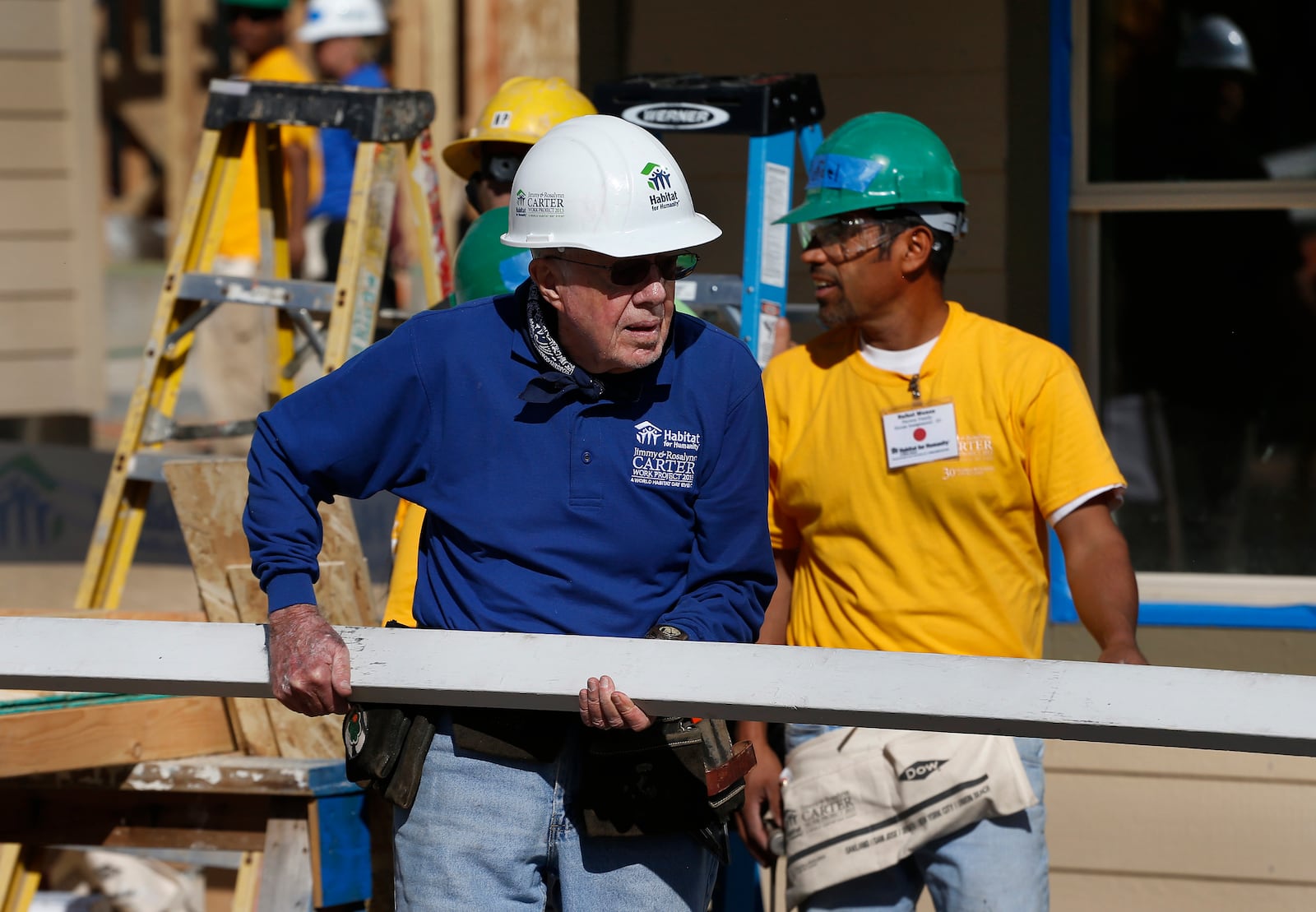 FILE - Former President Jimmy Carter helps cut wood for home construction at a Habitat for Humanity construction site in the Globeville neighborhood of Denver, Wednesday Oct. 9, 2013. (AP Photo/Brennan Linsley, File)