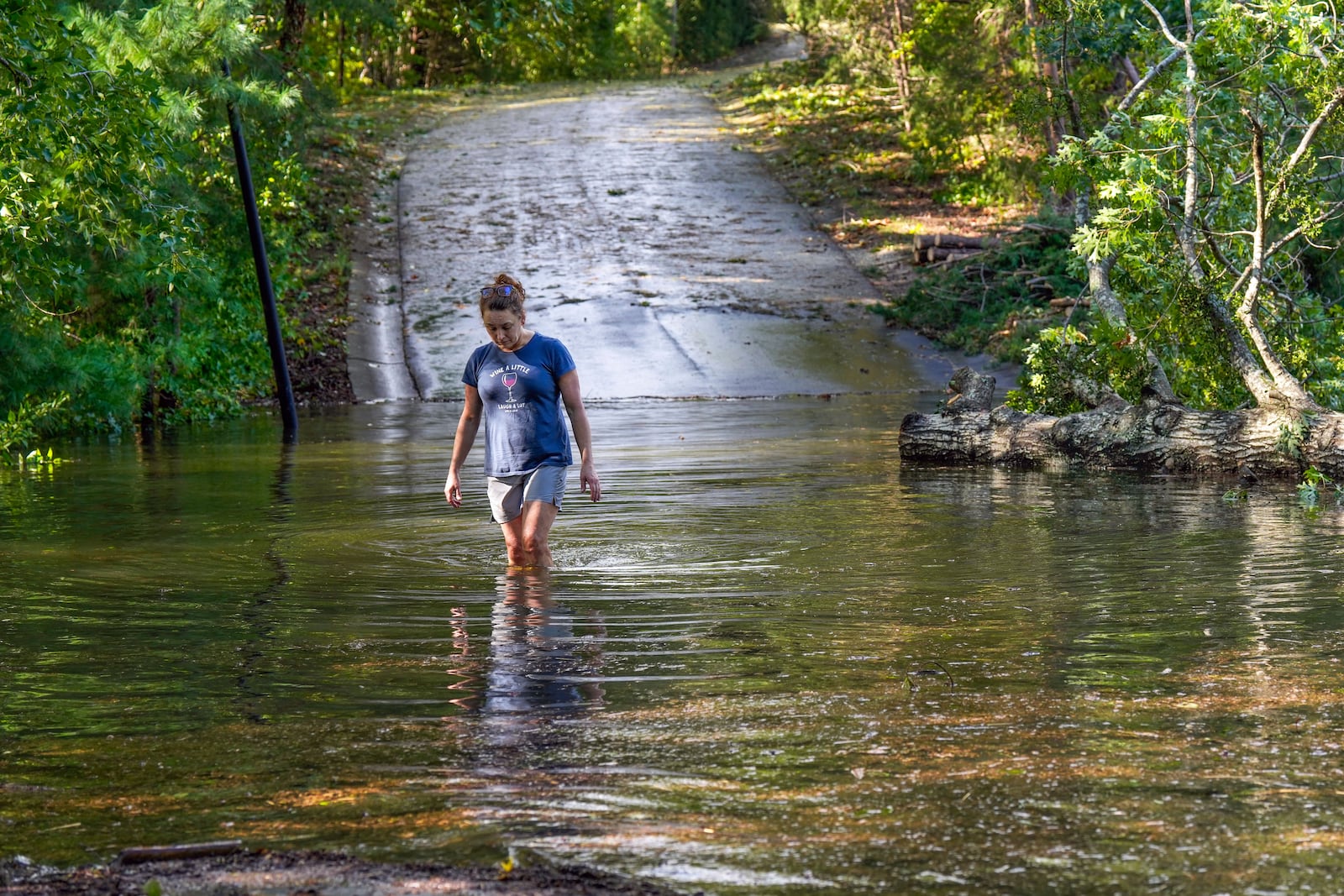 Teresa Elder walks through a flooded Sandy Cove Drive, from Hurricane Helene Friday, Sept. 27, 2024 in Morganton, N.C. (AP Photo/Kathy Kmonicek)