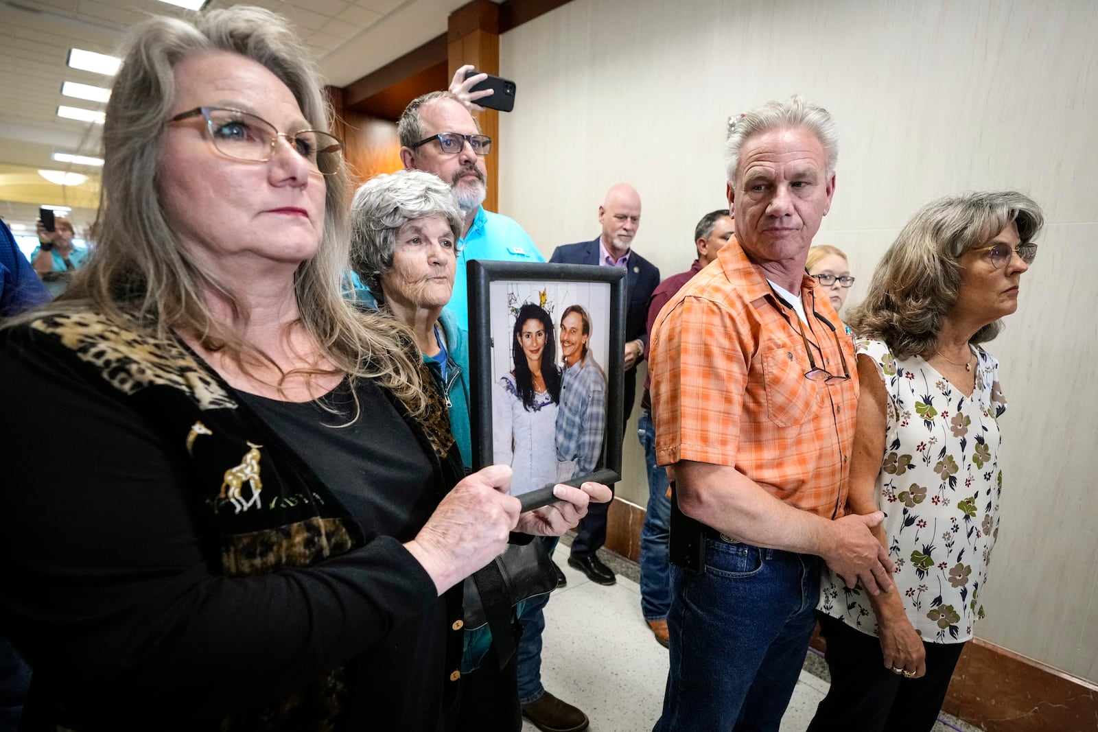 Elizabeth Ferrari, sister of Dennis Tuttle, holds a photo of her brother and Rhogena Nicholas, outside the courtroom after former Houston police officer Gerald Goines was sentenced to 60 years behind bars on a pair of felony murder convictions on Tuesday, Oct. 8, 2024, in Houston. Goines was found guilty of felony murder in the 2019 deaths of Tuttle and Nicholas. (Brett Coomer/Houston Chronicle via AP)