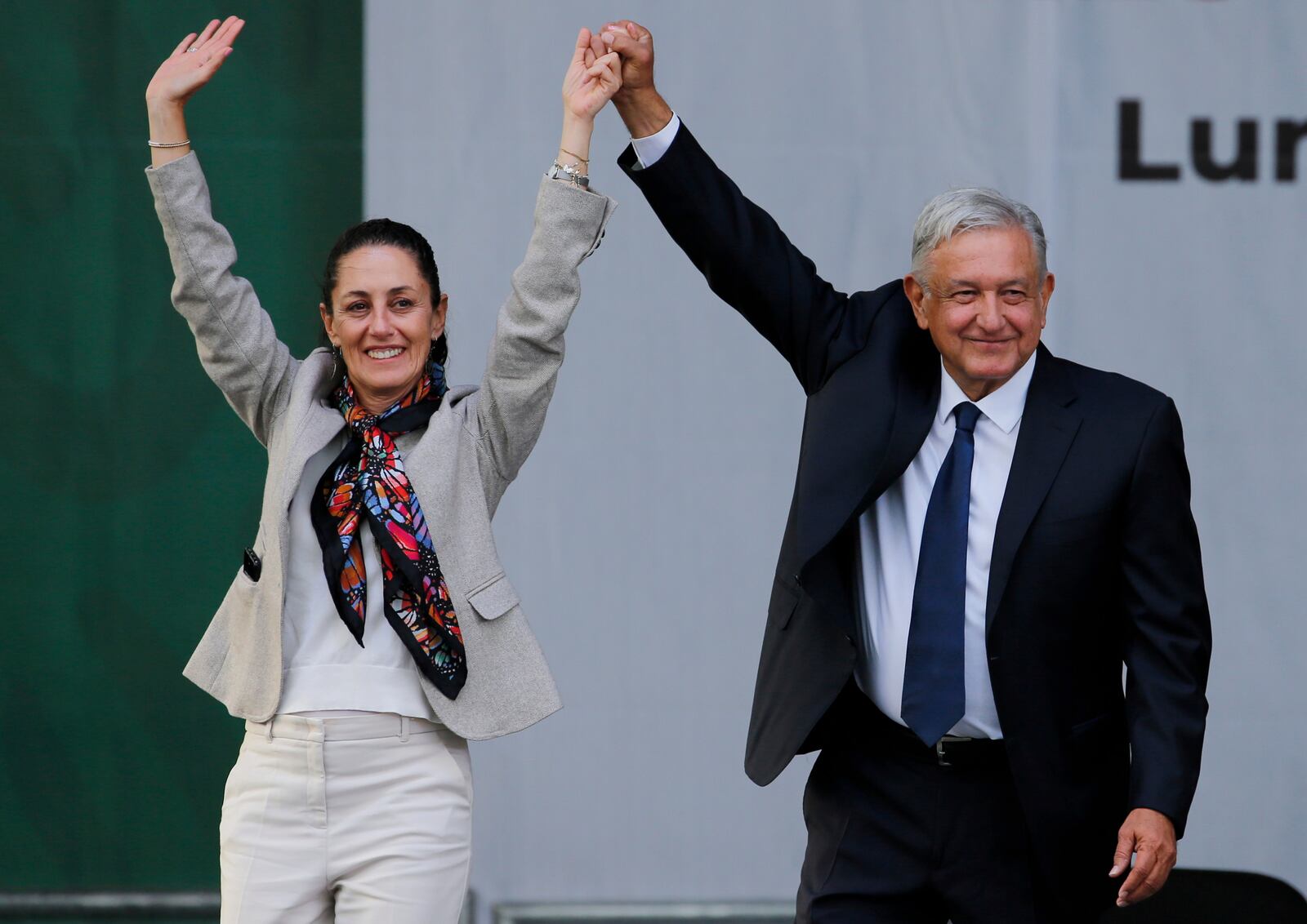 FILE - Mexican President Andres Manuel Lopez Obrador, right, and Mexico City's Mayor Claudia Sheinbaum greet supporters after a rally to celebrate the one-year anniversary of his election in the Zocalo of Mexico City, July 1, 2019. (AP Photo/Fernando Llano, File)