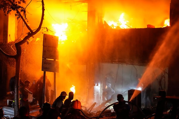 Civil defense workers extinguish a fire from the site of an Israeli airstrike in Beirut, Sunday, Nov. 17, 2024. (AP Photo/Hassan Ammar)