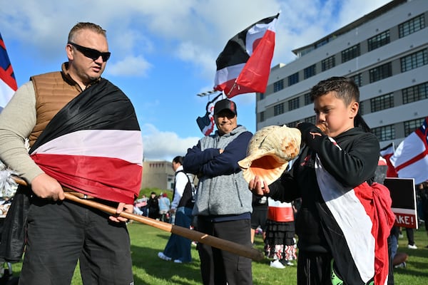 Te Haukūnui Hokianga, 8 years old, blows into a sea shell ahead of a march by indigenous Māori to Parliament in Wellington, New Zealand, Tuesday, Nov. 19, 2024. (AP Photo/Mark Tantrum)