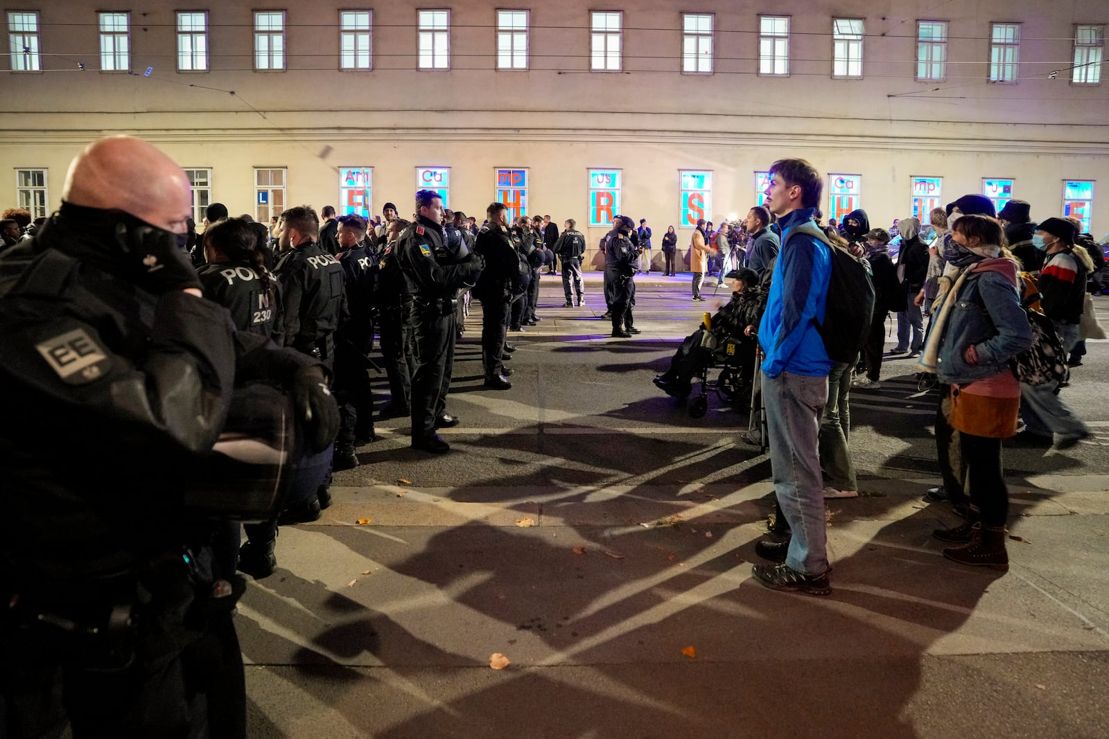 Austrian riot police officers block face anti right wing protesters, in Vienna, Austria, Sunday, Sept. 29, 2024, after polls closed in the country's national election. (AP Photo/Andreea Alexandru)