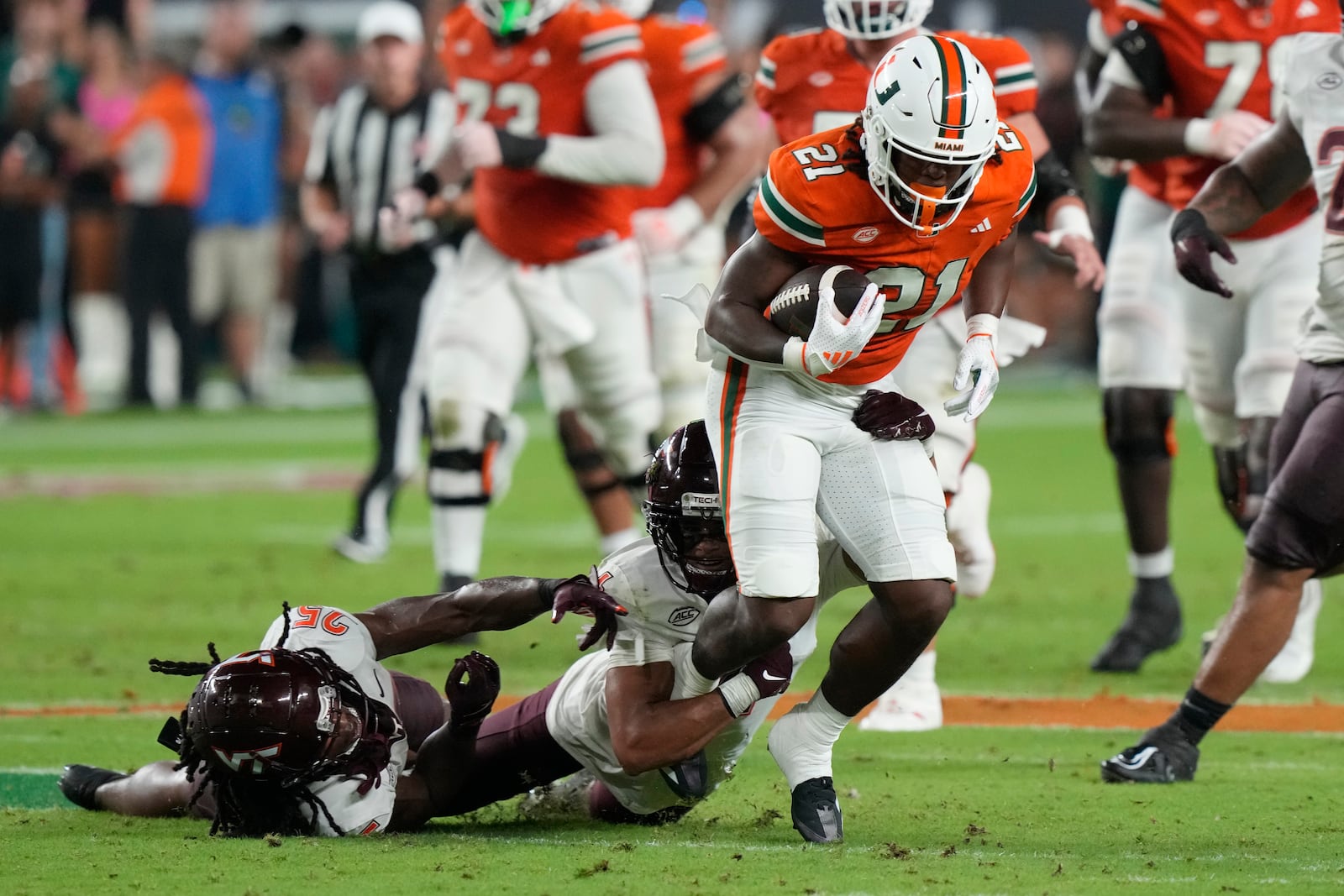 Virginia Tech cornerback Mansoor Delane grabs Miami running back Jordan Lyle (21) during the first half of an NCAA college football game, Friday, Sept. 27, 2024, in Miami Gardens, Fla. (AP Photo/Marta Lavandier)