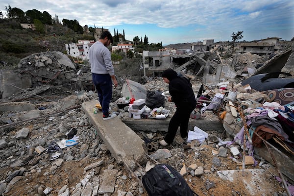 Residents collect personal remains from their destroyed house after they returned to Chehabiyeh village, southern Lebanon, Thursday, Nov. 28, 2024 following a ceasefire between Israel and Hezbollah that went into effect on Wednesday.(AP Photo/Hussein Malla)