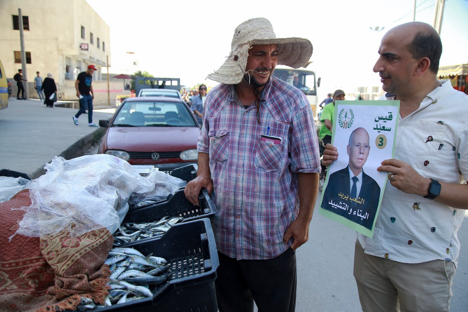 A supporter of Tunisian President and candidate for re-election Kais Saied meets with residents of a neighbourhood during a campaign tour, in Ariana, Tunisia, Thursday, Sept. 26, 2024. (AP Photo/Anis Mili)