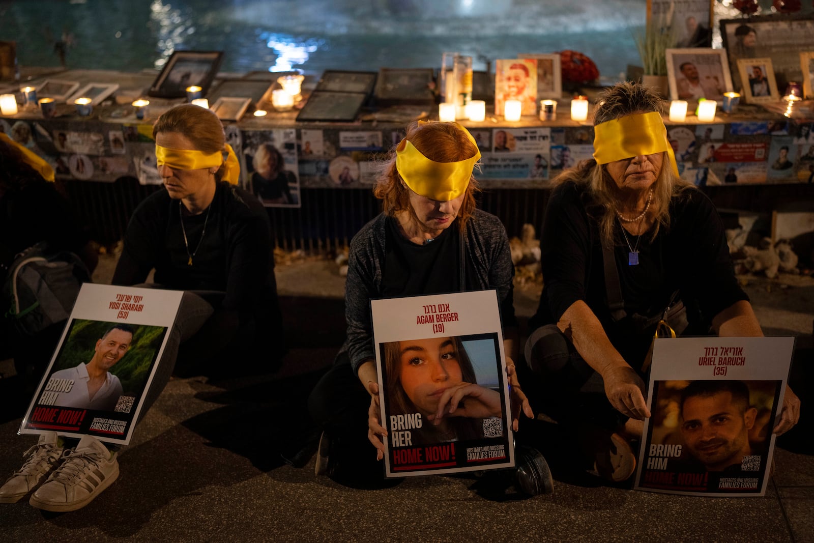 Activists sit blindfolded to mark one year in the Hebrew calendar since the Hamas cross-border attack on Israel in a protest against the celebration of the Jewish holiday of Simchat Torah while hostages are still held in Gaza, in Tel Aviv, Israel, Thursday, Oct. 24, 2024. (AP Photo/Oded Balilty)