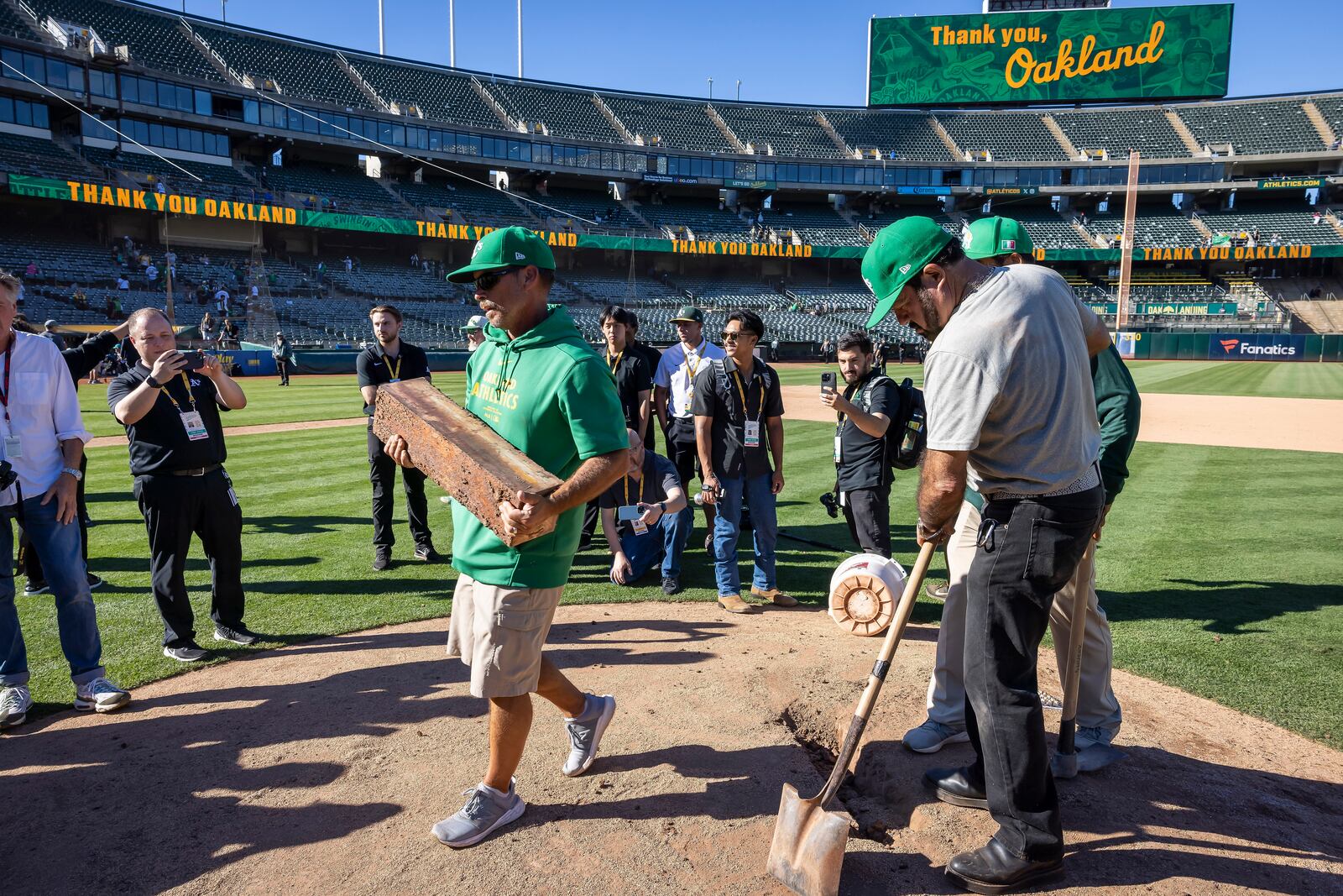 Rich Navarro, center left, of the Coliseum grounds crew carries, the pitching rubber off the mound after it was removed and authenticated after the Oakland Athletics defeated the Texas Rangers in Oakland, Calif., Thursday, Sept. 26, 2024. It was the Athletics final home game at the Coliseum. (Carlos Avila Gonzalez/San Francisco Chronicle via AP)