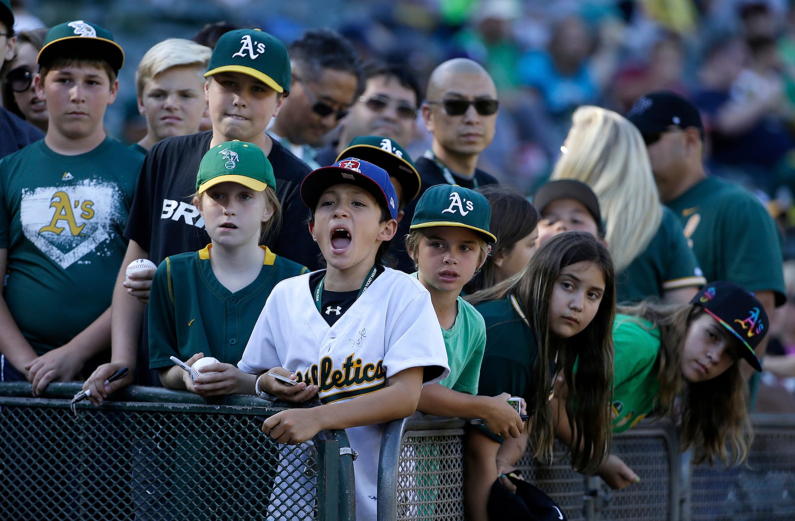 FILE - Fans wait for autographs before a baseball game between the Oakland Athletics and the Seattle Mariners in Oakland, Calif., July 3, 2015. (AP Photo/Jeff Chiu, File)