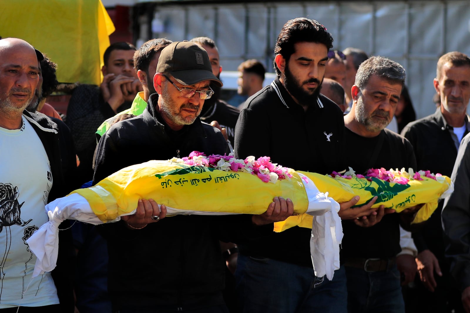 Mourners carry the bodies of two kids, killed on Monday evening in an Israeli airstrike, during a mass funeral in Saksakiyeh village, south Lebanon, Wednesday, Nov. 13, 2024.(AP Photo/Mohammed Zaatari)