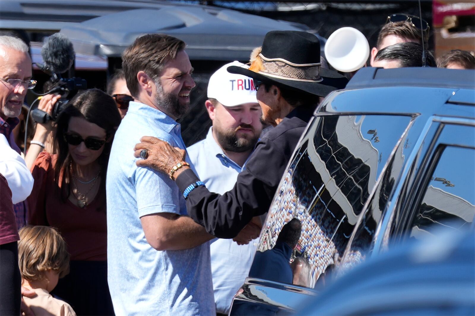 Republican vice presidential nominee Sen. JD Vance, R-Ohio, left chats with NASCAR Hall of Fame driver Richard Petty, right, during a campaign visit to Charlotte Motor Speedway in Concord, N.C., Sunday, Oct. 13, 2024. (AP Photo/Chuck Burton)