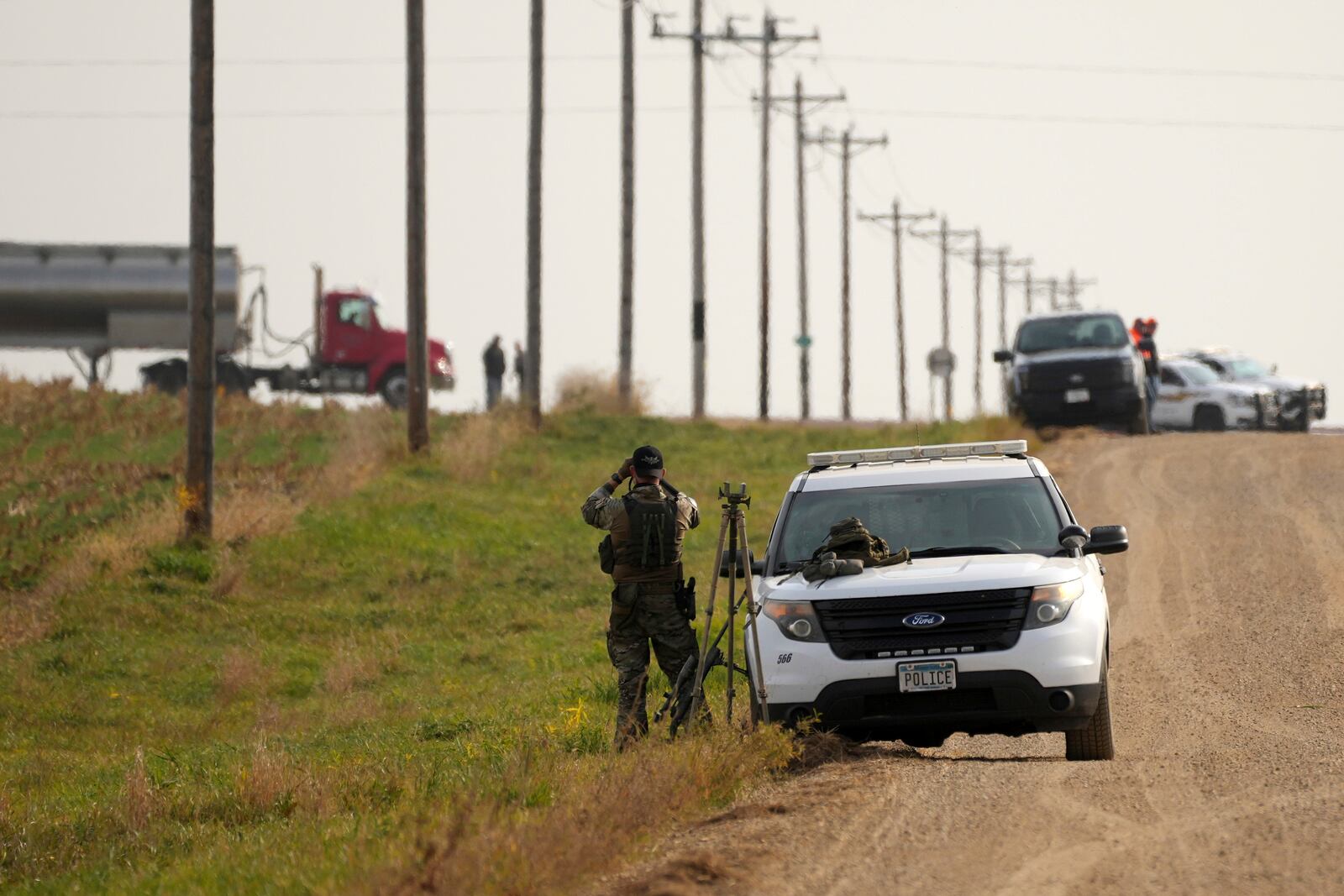 Local police and Secret Service surround the area as Minnesota Governor and Democratic Vice Presidential candidate Tim Walz takes part in the annual Minnesota Governor's Pheasant Hunting Opener, Saturday, Oct. 12, 2024, near Sleepy Eye, Minn. (Anthony Souffle/Star Tribune via AP)