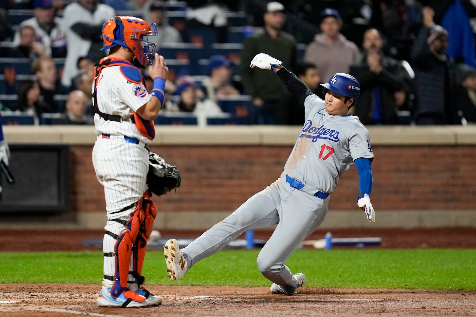 Los Angeles Dodgers' Shohei Ohtani scores past New York Mets catcher Francisco Alvarez on a double by Mookie Betts during the fourth inning in Game 4 of a baseball NL Championship Series, Thursday, Oct. 17, 2024, in New York. (AP Photo/Ashley Landis)