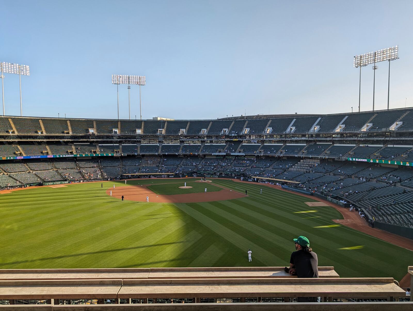 A fan standing in left field during a sparsely attended game between the Oakland A's and Colorado Rockies, May 22, 2024, at the Oakland Coliseum in Oakland, Calif. (AP Photo/Michael Liedtke)