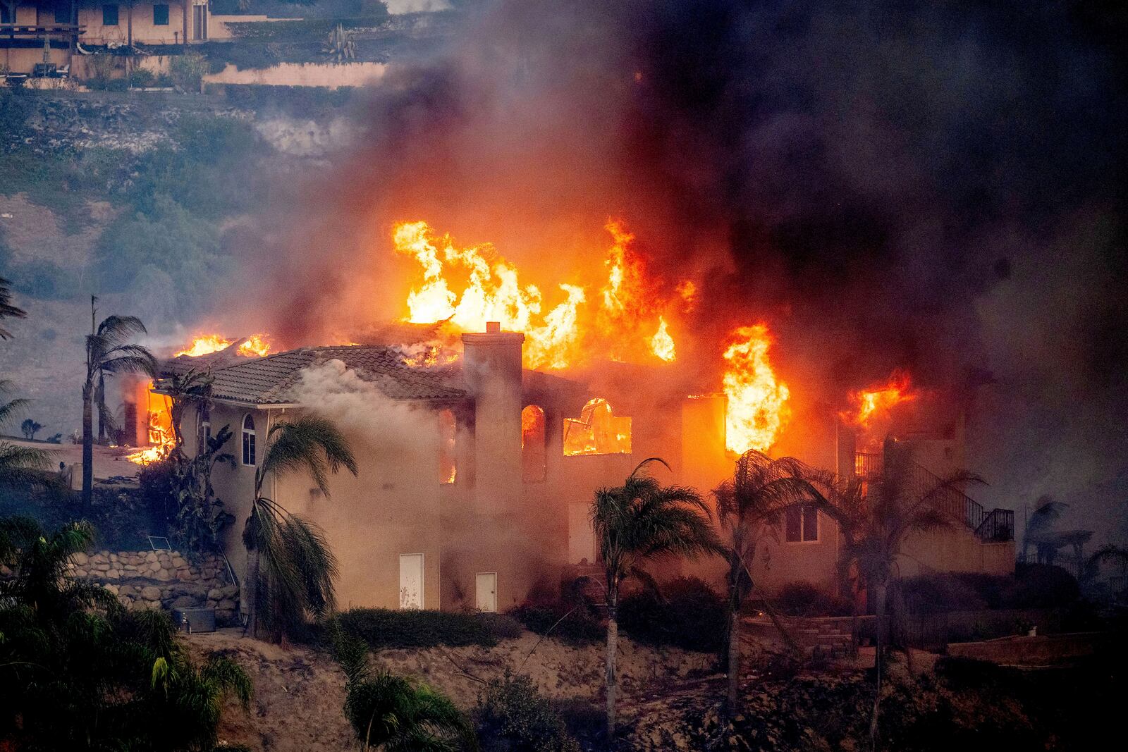 Flames consume a home as the Mountain Fire burns in Camarillo, Calif., on Wednesday, Nov. 6, 2024. (AP Photo/Noah Berger)