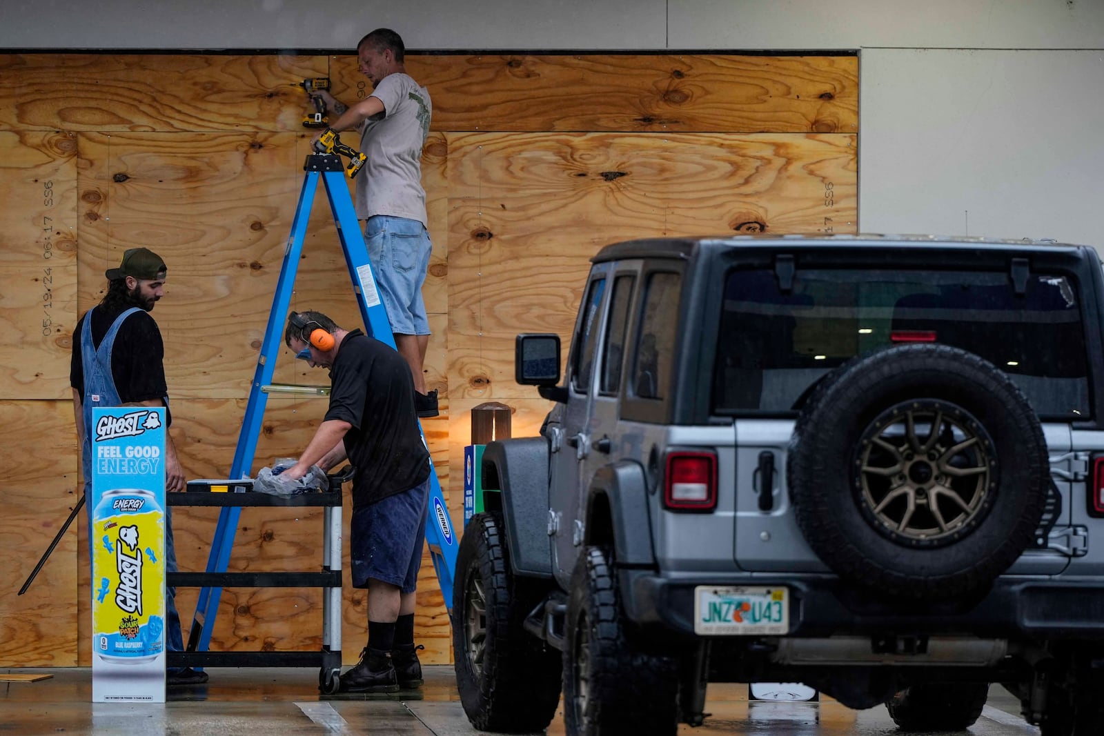 People board up a convenience store ahead of Hurricane Milton, Wednesday, Oct. 9, 2024, in Brandon, Fla. (AP Photo/Mike Stewart)