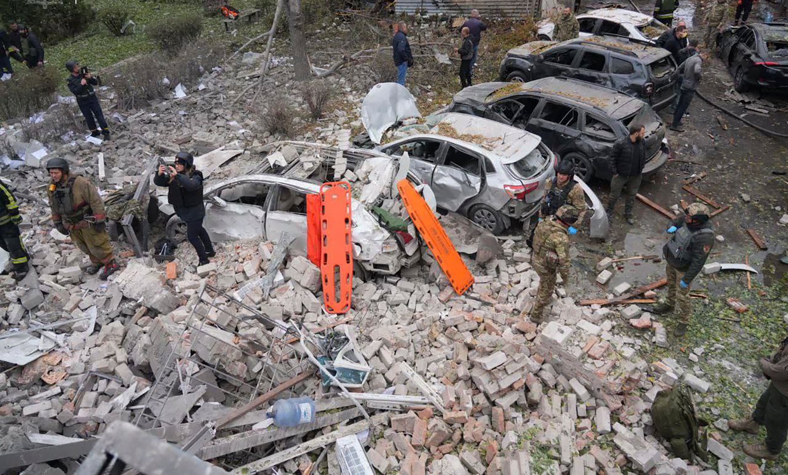 In this photo provided by the Ukrainian Emergency Service, emergency workers clear the rubble after Russia attacked the city with guided bombs overnight in Zaporizhzhia, Ukraine, Monday, Oct. 21, 2024. (Ukrainian Emergency Service via AP)