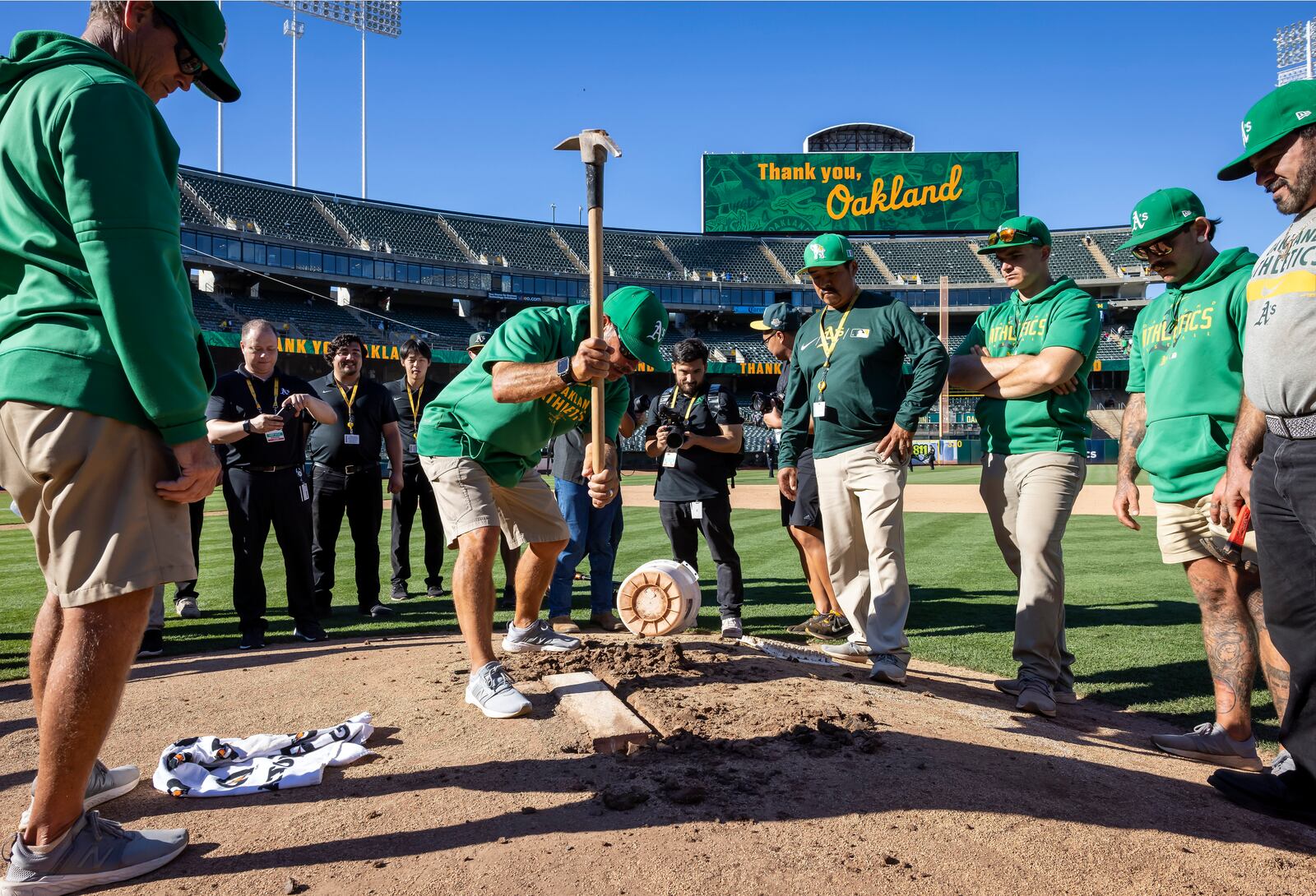 Rich Navarro, center left, of the Coliseum grounds crew, digs around the pitching rubber on the mound which was removed and authenticated after the Oakland Athletics defeated the Texas Rangers in a baseball game in Oakland, Calif., Thursday, Sept. 26, 2024. It was the Athletic's final home game at the Coliseum. (Carlos Avila Gonzalez/San Francisco Chronicle via AP)