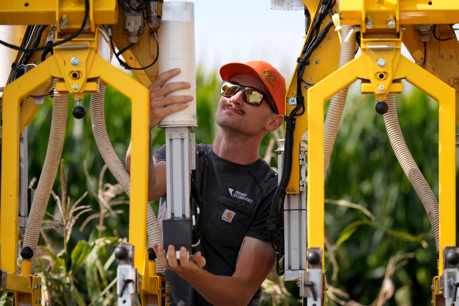 PowerPollen intern Evan Mark prepares a pollen applicator, Thursday, Aug. 22, 2024, near Ames, Iowa. (AP Photo/Charlie Neibergall)