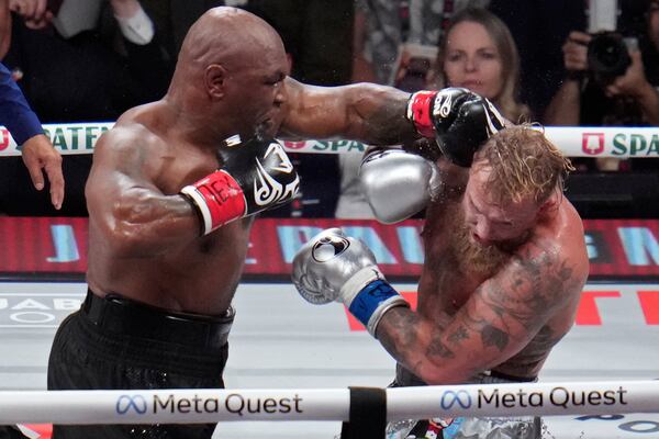 Mike Tyson hits Jake Paul during their heavyweight boxing match, Friday, Nov. 15, 2024, in Arlington, Texas. (AP Photo/Julio Cortez)