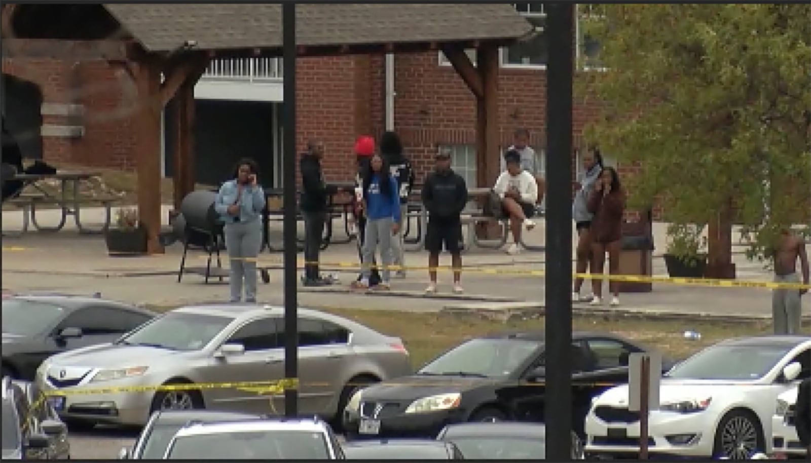 This image taken from video provided by WSFA shows people standing near the scene of an earlier shooting at Tuskegee University, Sunday, Nov. 10, 2024, in Tuskegee, Ala. (WSFA via AP)