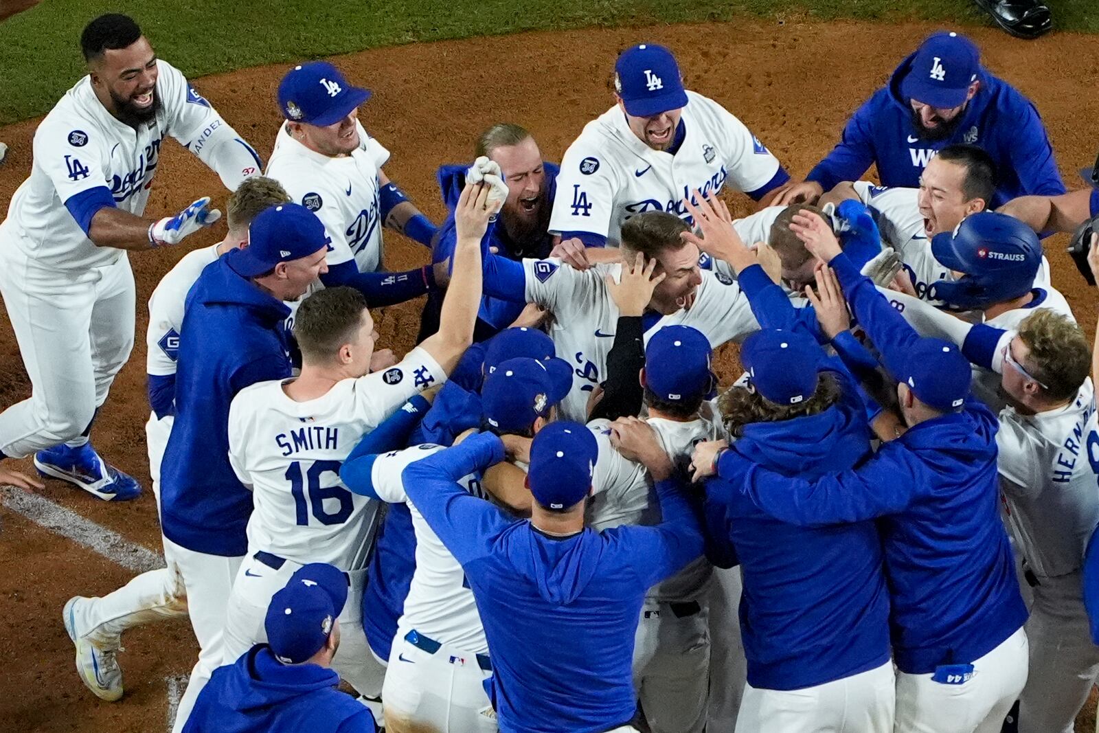 Los Angeles Dodgers' Freddie Freeman is mobbed by teammates at home plate after his walk-off grand slam home run during the 10th inning in Game 1 of the baseball World Series against the New York Yankees, Friday, Oct. 25, 2024, in Los Angeles. (AP Photo/Mark J. Terrill)