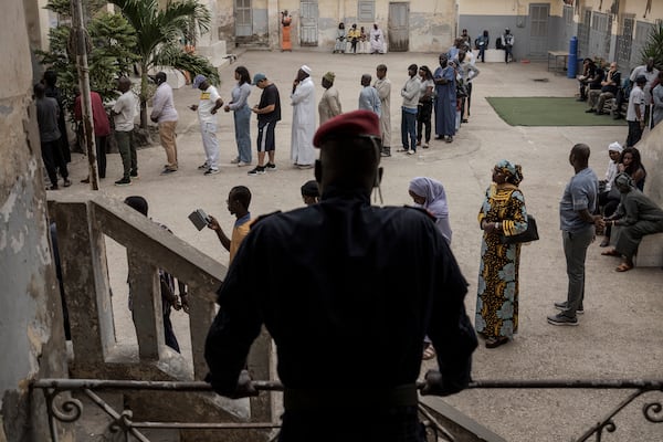 People wait to cast their ballot for legislative elections in Dakar, Senegal Sunday, Nov. 17, 2024. (AP Photo/Annika Hammerschlag)