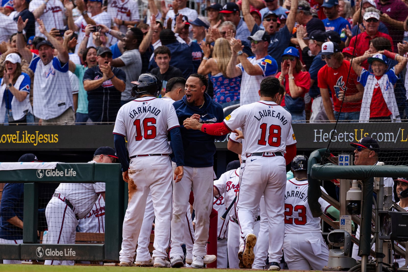 Atlanta Braves' Travis d'Arnaud, left, Orlando Arcia, center, and Ramón Laureano, right, celebrate after scoring in the eighth inning of a baseball game against the New York Mets, Monday, Sept. 30, 2024, in Atlanta. (AP Photo/Jason Allen)