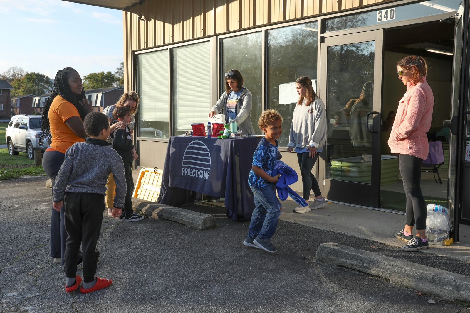 Madiera Maxwell, left, checks in her two children, nephew and niece to the Project:Camp pop-up daycamp for families impacted by Hurricane Helene in Brevard, N.C., Tuesday, Oct. 8, 2024. (AP Photo/Gabriela Aoun Angueira)