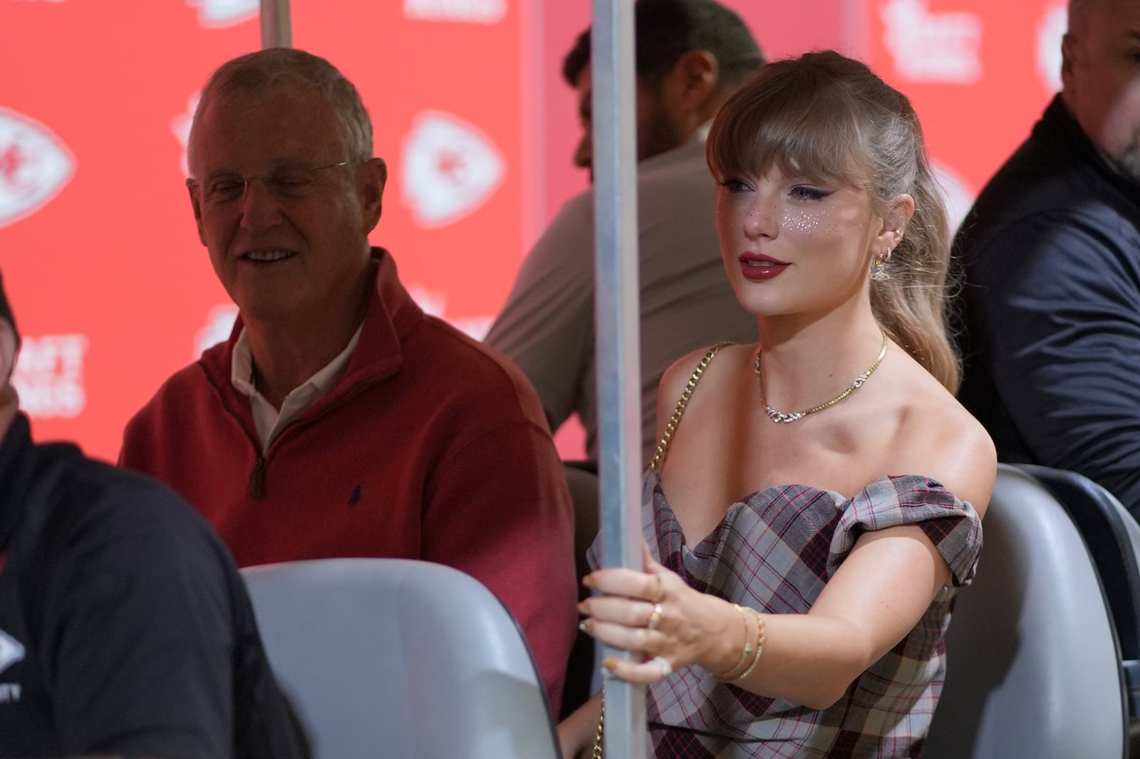 Taylor Swift arrives in a cart with her dad, Scott Swift, left, before the start of an NFL football game between the Kansas City Chiefs and the New Orleans Saints Monday, Oct. 7, 2024, in Kansas City, Mo. (AP Photo/Charlie Riedel)