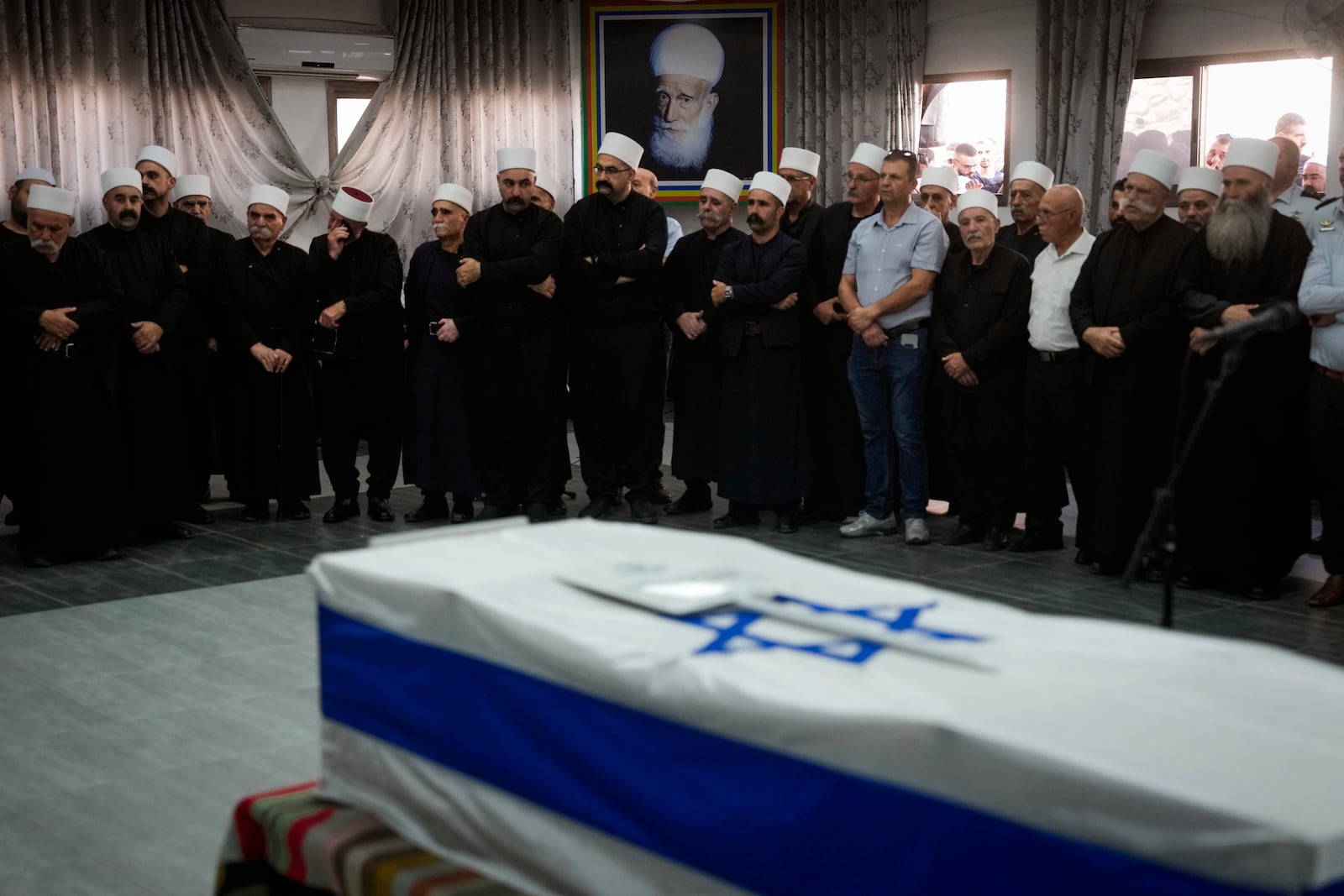 Mourners gather around the flag-draped casket of Israeli reservist Major Nael Fwarsy, one of two soldiers killed by a Lebanese drone attack on northern Israel, during his funeral in Maghar, Israel, Friday, Sept 20, 2024. (AP Photo/Ohad Zwigenberg)