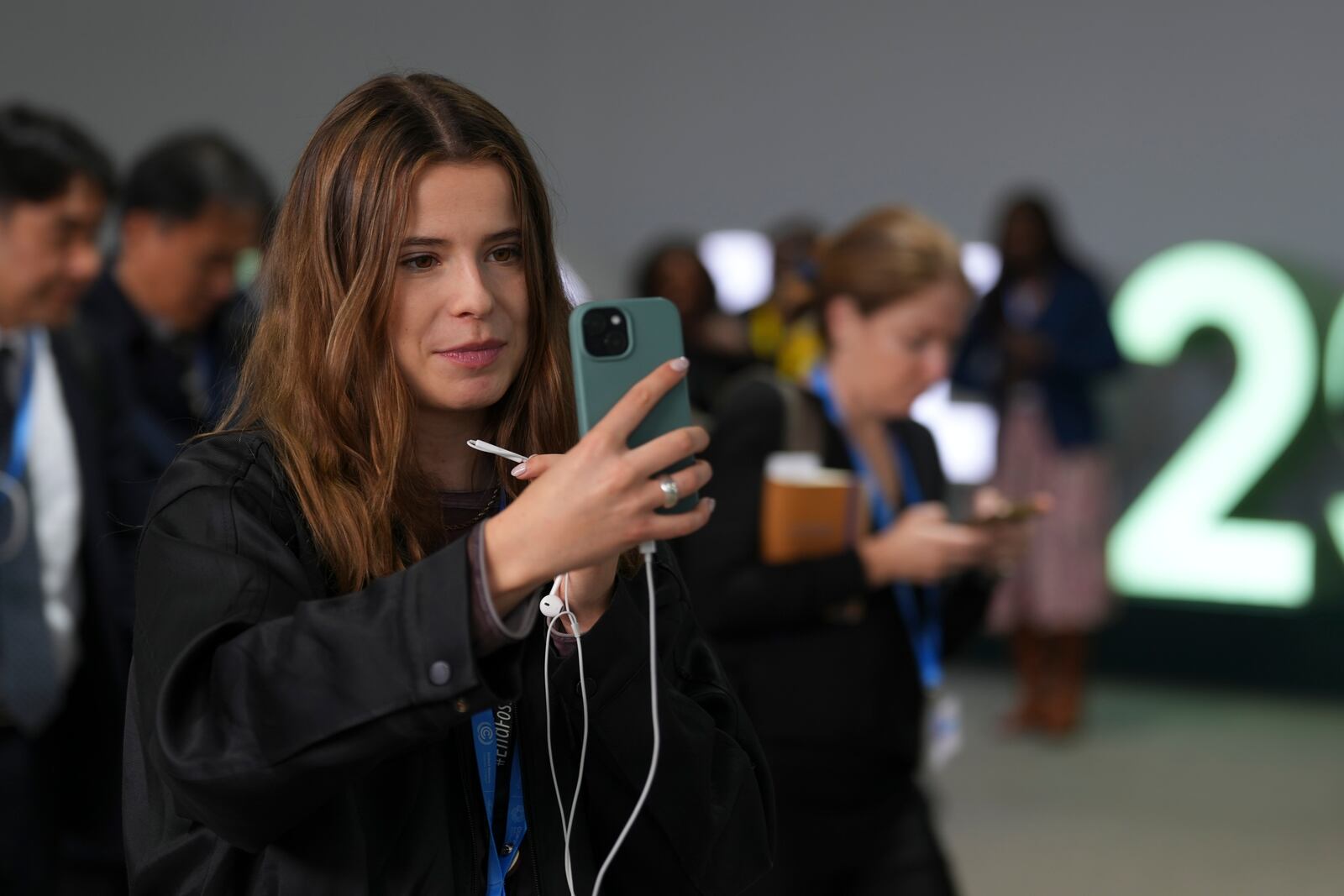 Activist Luisa Neubauer, of Germany, records on her phone at the COP29 U.N. Climate Summit, Thursday, Nov. 14, 2024, in Baku, Azerbaijan. (AP Photo/Peter Dejong)