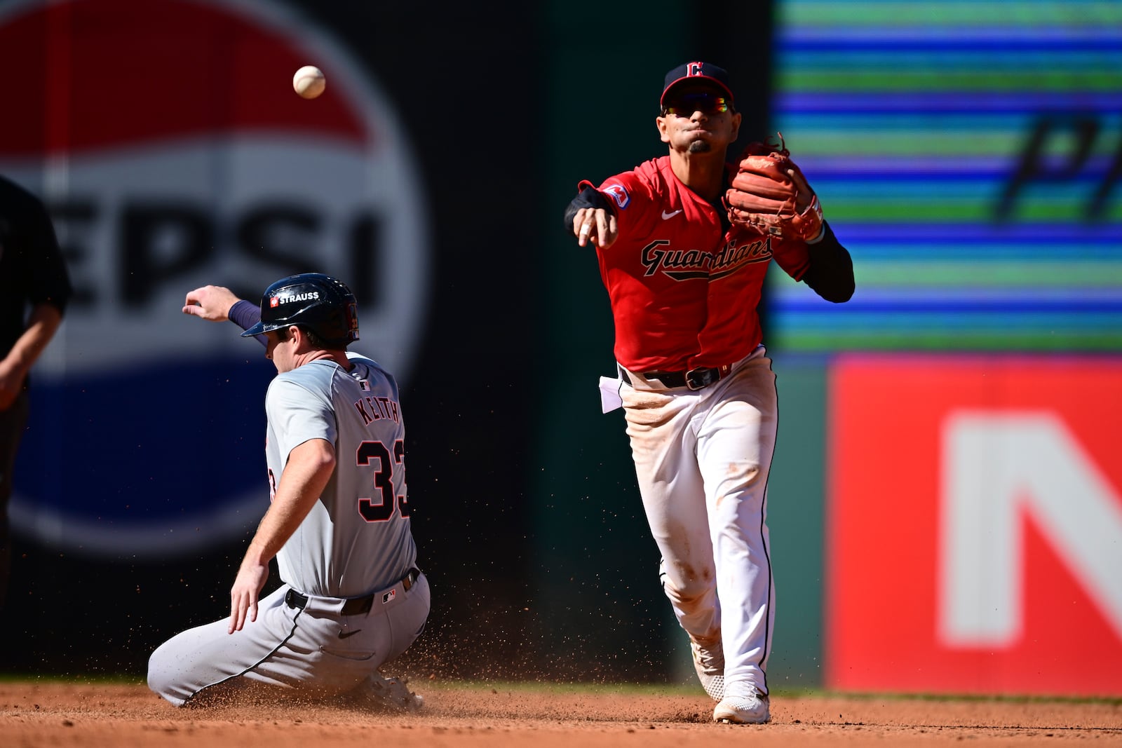 Cleveland Guardians second baseman Andres Gimenez, right, throws the ball to first base after forcing out Detroit Tigers' Colt Keith (33) at second base on a double play ball hit by Spencer Torkelson in the fourth inning during Game 1 of baseball's AL Division Series, Saturday, Oct. 5, 2024, in Cleveland. (AP Photo/David Dermer)