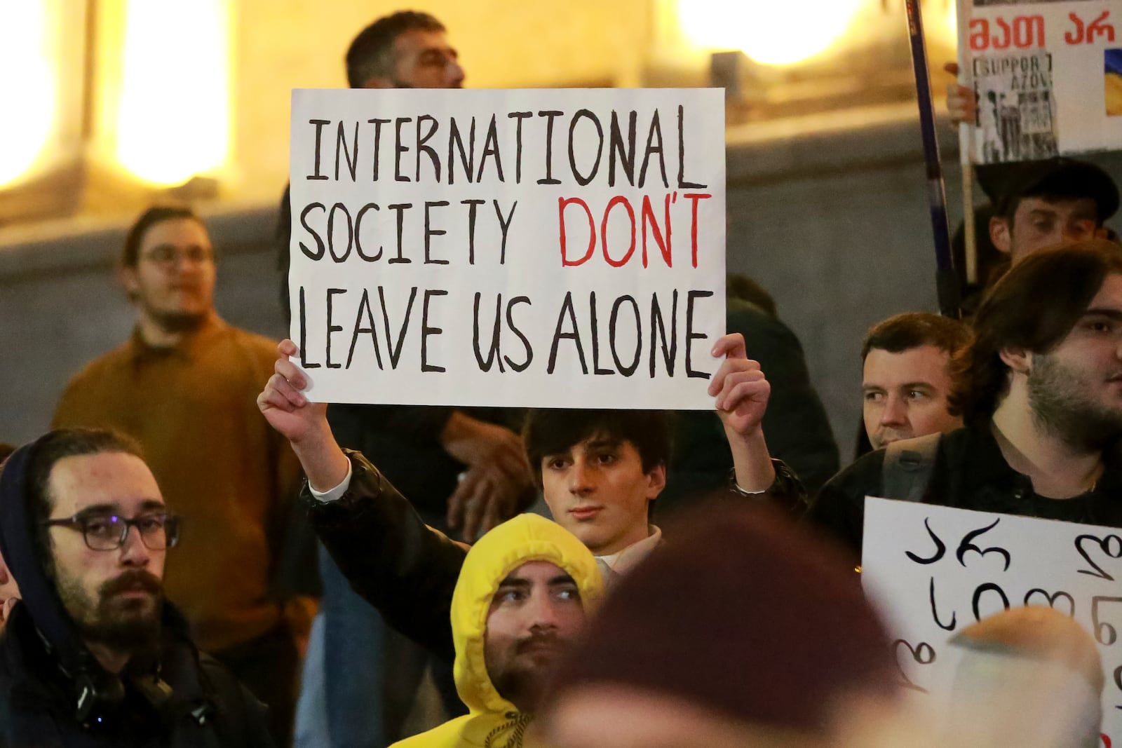 A protester holds a poster during a rally against alleged violations in a recent parliamentary election in Tbilisi, Georgia, Monday, Nov. 4, 2024. (AP Photo/Zurab Tsertsvadze)