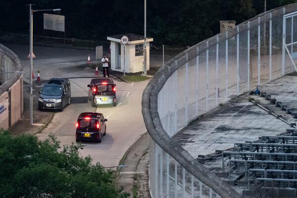 Vehicles believed to be carrying former pro-democracy lawmaker Gary Fan, who was released after four years for his conviction under the national security law, leaves the Shek Pik Prison in Hong Kong, Tuesday, April 29, 2025. (AP Photo/Chan Long Hei)