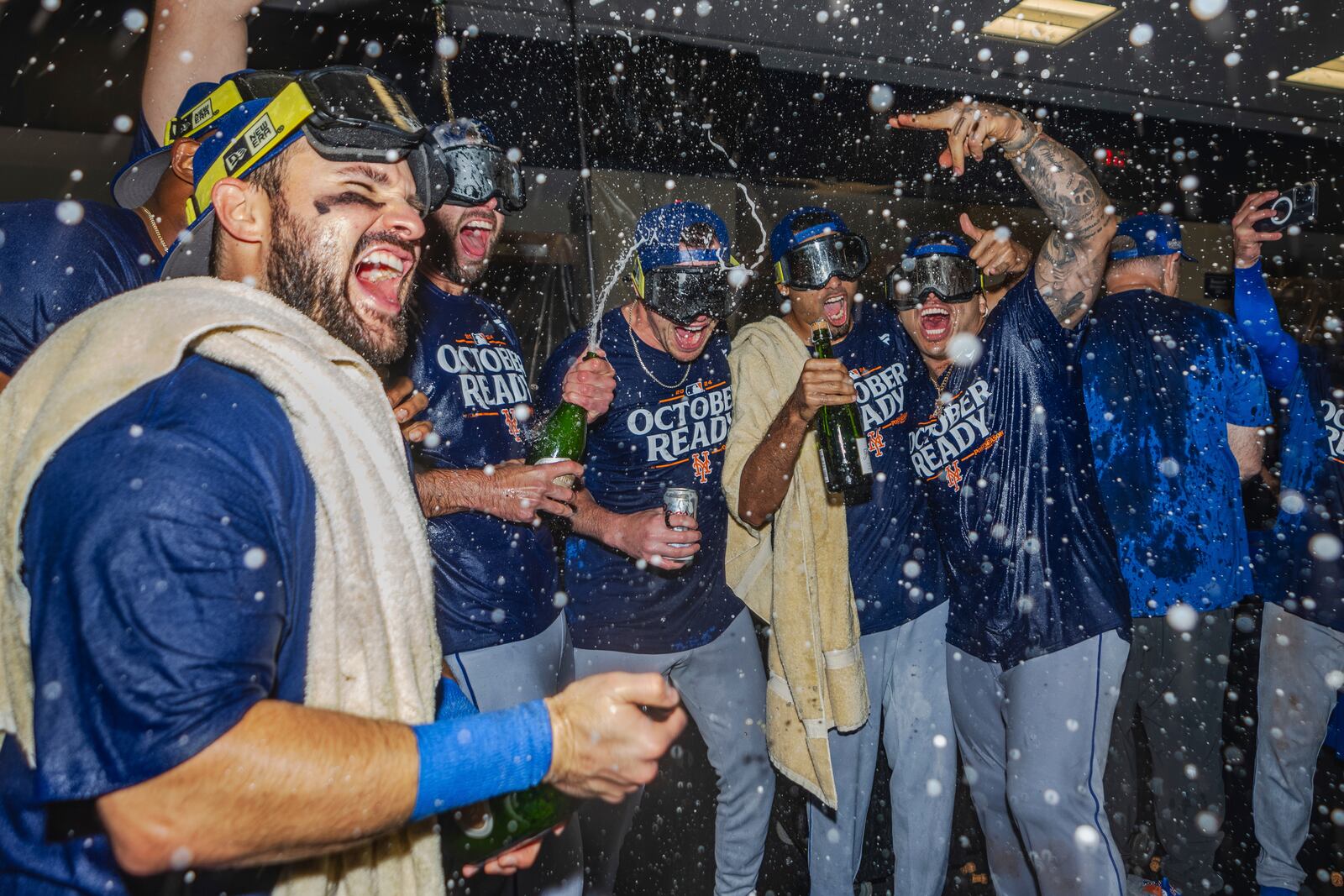 The New York Mets celebrate in the locker room after clinching a wild-card playoff berth after the second baseball game of a doubleheader against the Atlanta Braves, Monday, Sept. 30, 2024, in Atlanta. (AP Photo/Jason Allen)