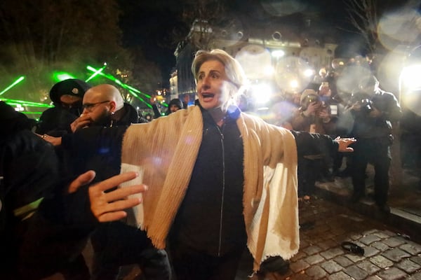 A woman reacts standing in front of police blocked protesters pouring into the streets following Georgian Prime Minister Irakli Kobakhidze's announcement, rallying outside the parliament building in Tbilisi, Georgia, on Friday, Nov. 29, 2024. (AP Photo/Zurab Tsertsvadze)