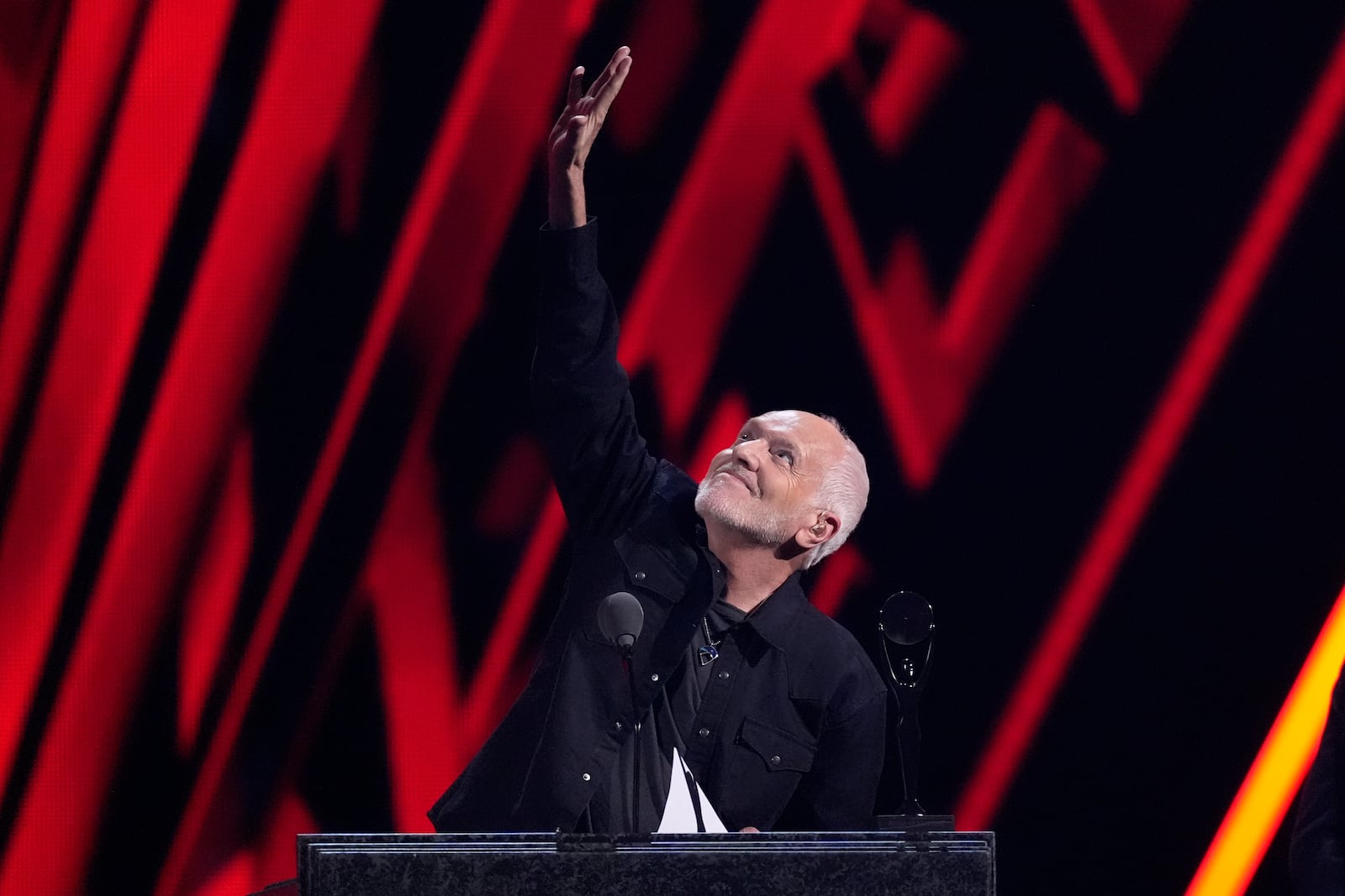 Peter Frampton raises his hand in recognition of David Bowie during the 39th Annual Rock & Roll Hall of Fame Induction Ceremony on Saturday, Oct. 19, 2024, at Rocket Mortgage FieldHouse in Cleveland. (AP Photo/Chris Pizzello)