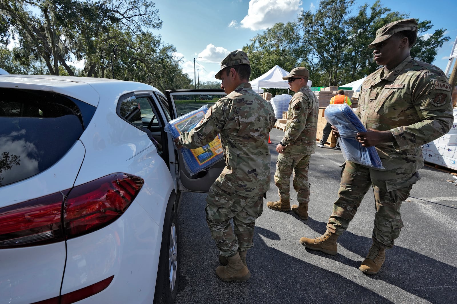 Members of the Florida Air National Guard load supplies into residents displace by Hurricane Milton, Sunday, Oct. 13, 2024, at the Hillsborough Community College campus in Brandon, Fla. (AP Photo/Chris O'Meara)