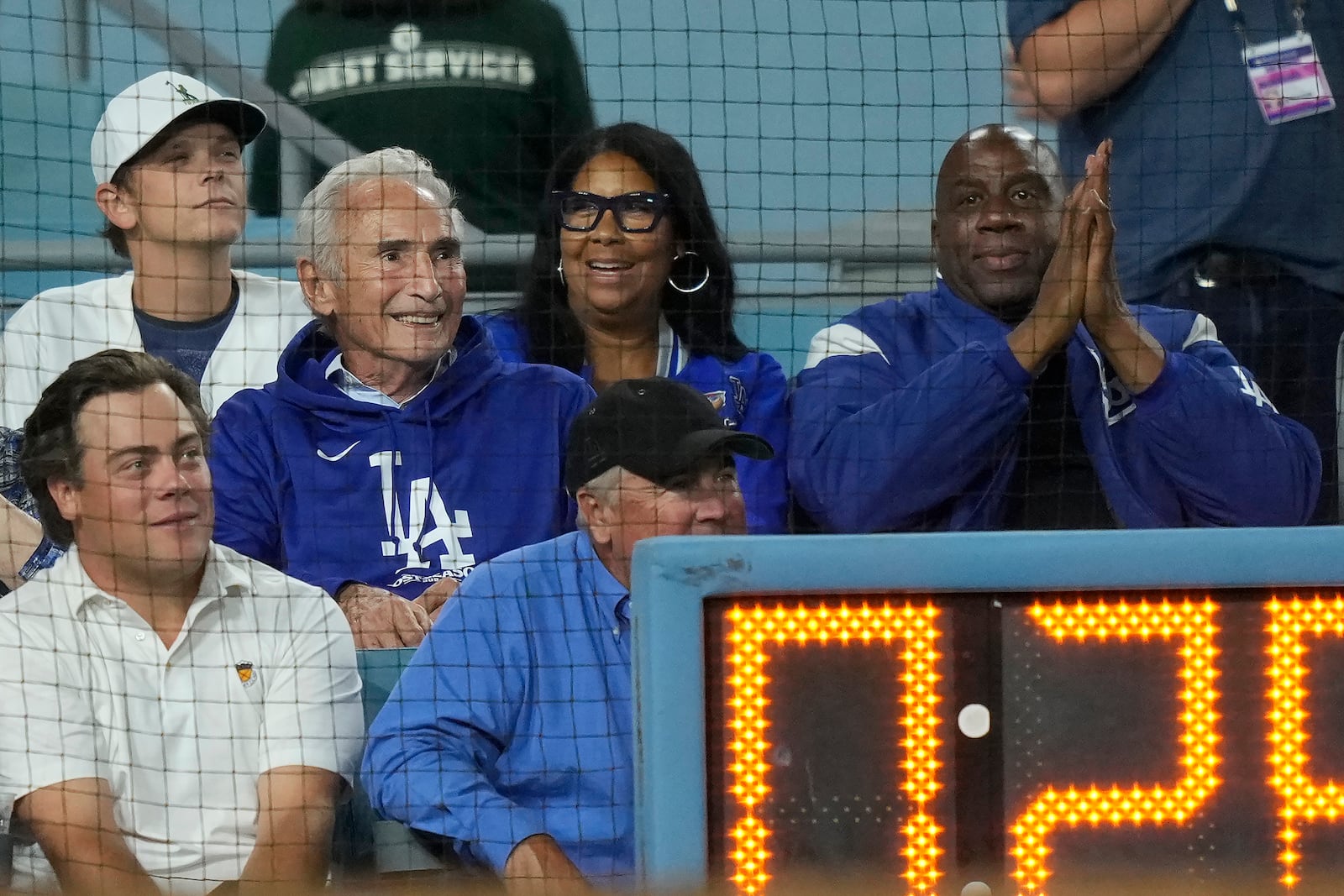 Sandy Koufax, middle left, Cookie Johnson, middle, and Magic Johnson, right, watch Game 1 of baseball's NL Division Series between the Los Angeles Dodgers and the San Diego Padres, Saturday, Oct. 5, 2024, in Los Angeles. (AP Photo/Mark J. Terrill)