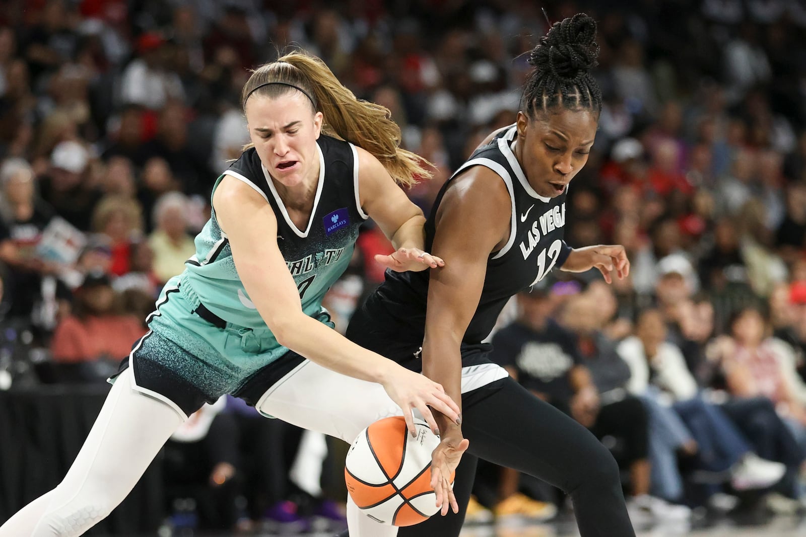 Las Vegas Aces guard Chelsea Gray knocks the ball away from New York Liberty guard Sabrina Ionescu (20) during the first half of a WNBA Semifinal game Sunday, Oct. 6, 2024, in Las Vegas. (AP Photo/Ian Maule)