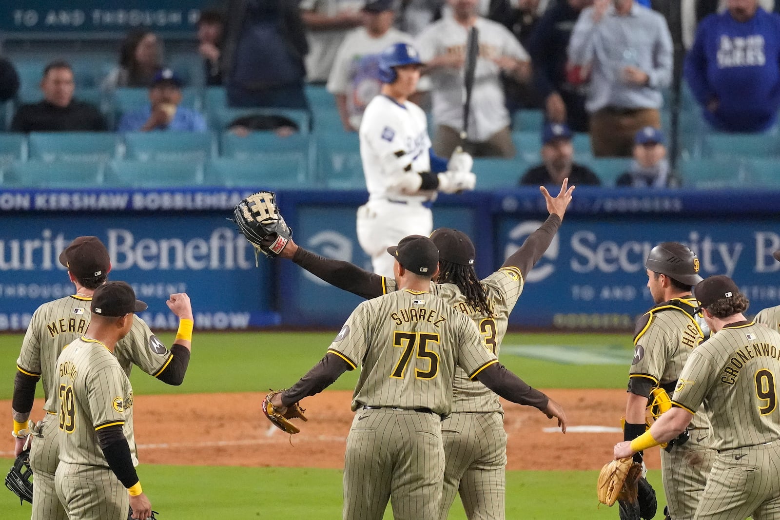 Members of the San Diego Padres celebrate after the Padres clinched a playoff spot with a triple play to end their baseball game as Los Angeles Dodgers' Shohei Ohtani stands at the plate, Tuesday, Sept. 24, 2024, in Los Angeles. (AP Photo/Mark J. Terrill)