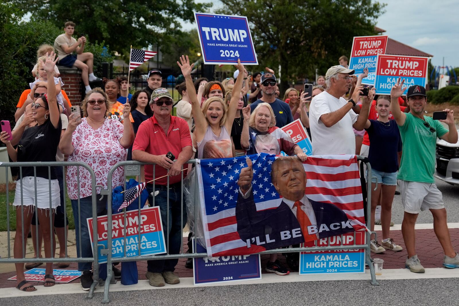 People line the road as Republican presidential nominee former President Donald Trump arrives to speak at a temporary relief shelter as he visits areas impacted by Hurricane Helene, Friday, Oct. 4, 2024, in Evans, Ga. (AP Photo/Evan Vucci)