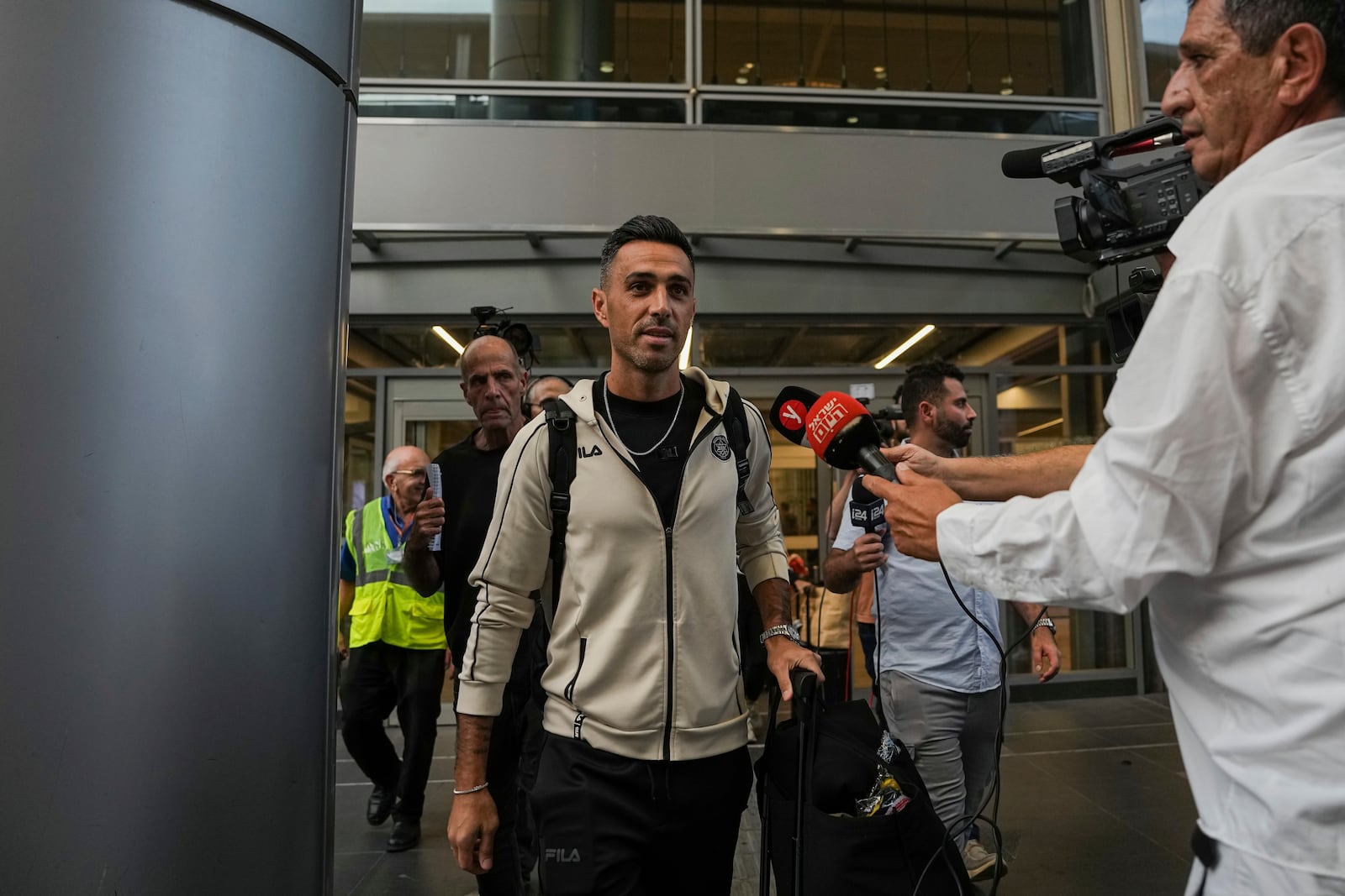 Eran Zahavi of Maccabi Tel Aviv, center, arrives at Israel's Ben-Gurion International Airport on a flight from Amsterdam, where Israeli soccer fans were attacked following a match between the Israeli club and Ajax Amsterdam, in Lod, Israel, Friday, Nov. 8, 2024. (AP Photo/Tsafrir Abayov)