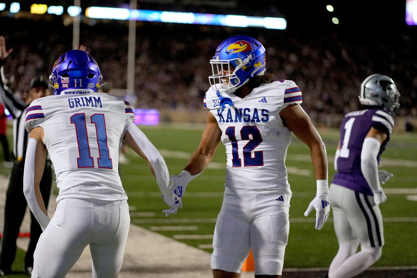 Kansas wide receiver Luke Grimm (11) celebrates with running back Torry Locklin (12) after scoring a touchdown during the first half of an NCAA college football game against Kansas State, Saturday, Oct. 26, 2024, in Manhattan, Kan. (AP Photo/Charlie Riedel)