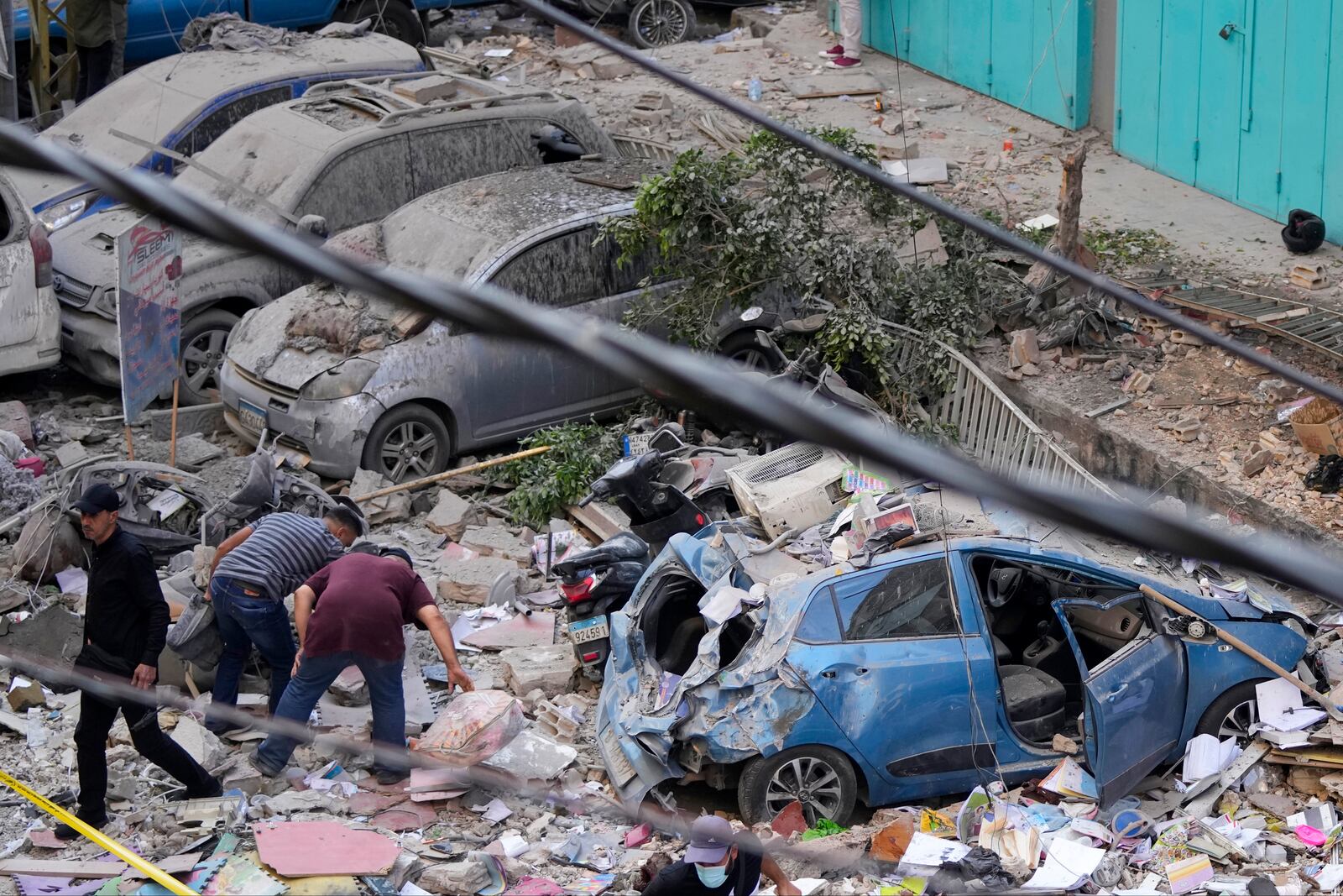 Residents check the site of an Israeli airstrike in Beirut's southern suburbs, Tuesday, Sept. 24, 2024. (AP Photo/Hassan Ammar)