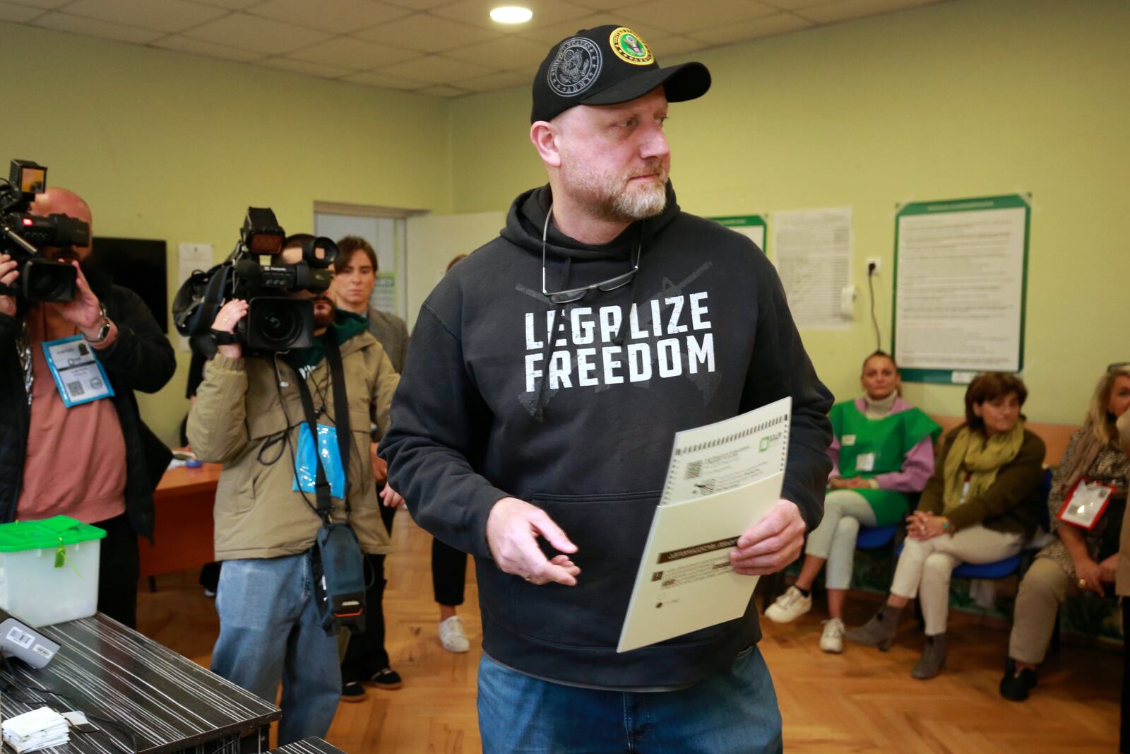 Zurab Japaridze, co-founder and chair of the Libertarian party, holds his ballot at a polling station during the parliamentary election in Tbilisi, Georgia, Saturday, Oct. 26, 2024. (AP Photo/Zurab Tsertsvadze)